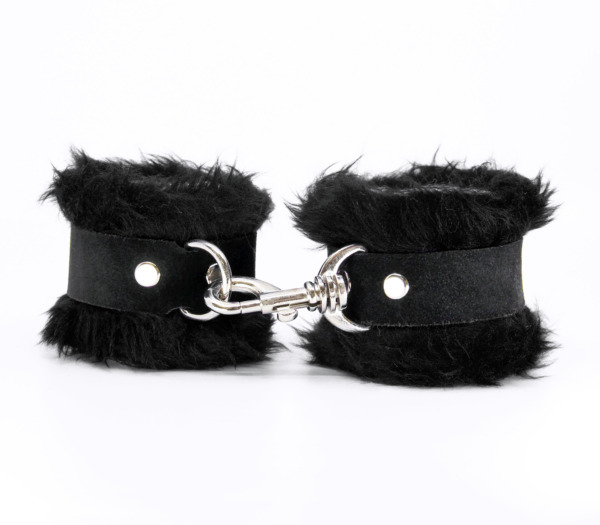 Front view of black fluffy wrist cuffs with black centre strap and silver snap.