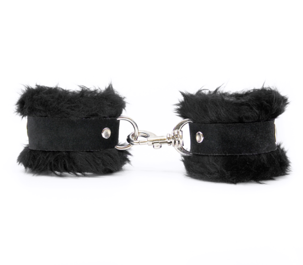 Side view of black fluffy wrist cuffs with black centre strap and silver snap.