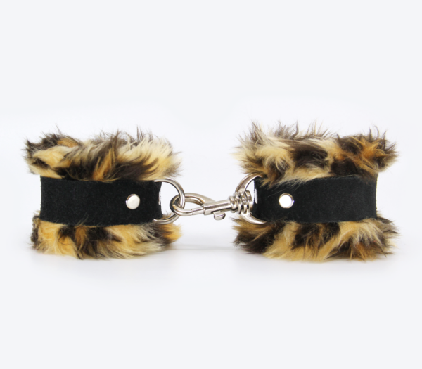 Side view of striped brown animal print fluffy wrist cuffs with black centre strap and silver snap.