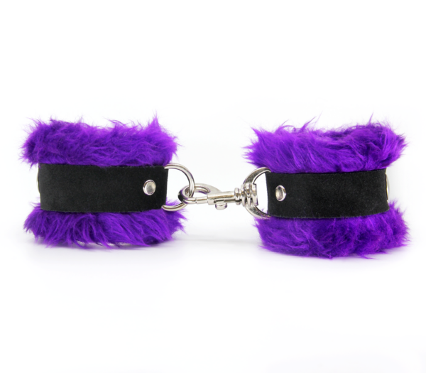 Side view of purple fluffy wrist cuffs with black centre strap and silver snap.