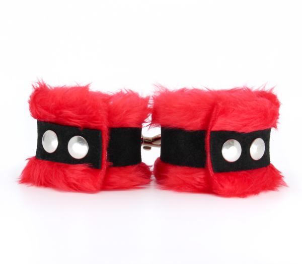 Back view of red fluffy wrist cuffs with black centre strap and silver snap buttons.