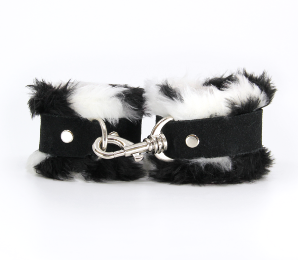 Front view of black and white fluffy wrist cuffs with black centre strap and silver snap.